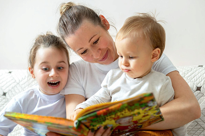 семья мама с детьми читает книгу