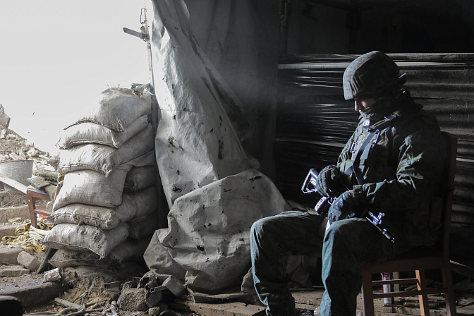 Российский военный на фронте сидит на стуле в укрытии