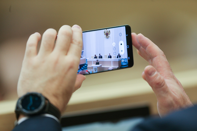 Смартфон в руках снимает на видео заседание СФ