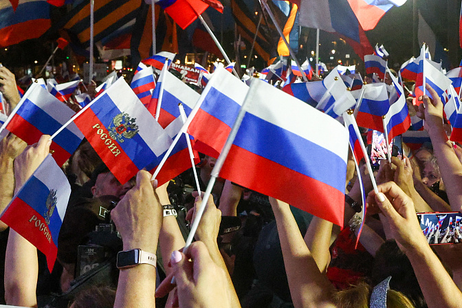 флаг россии в руках людей 