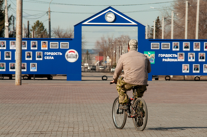 мужчина на велосипеде едет по селу